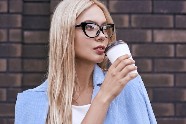 Jovem loira empresária tomando café