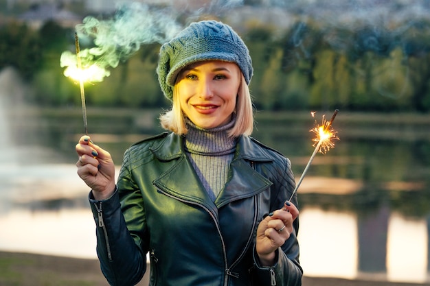 Jovem loira feliz sorridente mulher de casaco bege e chapéu quente ao ar livre closeup retrato no parque outono. Frio lá fora. Roupas de inverno primavera