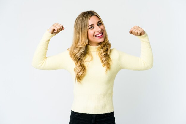 Jovem loira mostrando um gesto de força com os braços