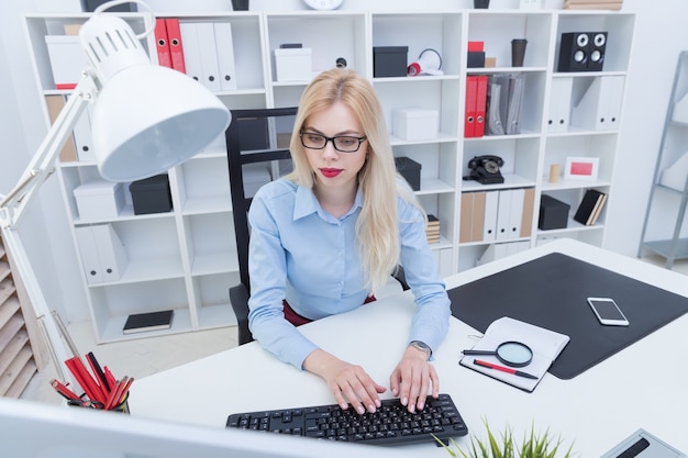Foto jovem loira no escritório trabalhando no computador
