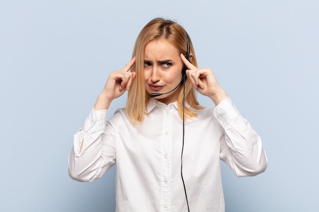 Jovem loira se sentindo confusa ou duvidando, concentrando-se em uma ideia, pensando muito, procurando copiar o espaço ao lado