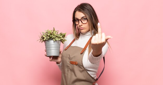 Jovem loira se sentindo irritada, irritada, rebelde e agressiva, sacudindo o dedo do meio, lutando