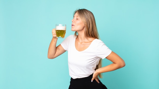 Jovem loira segurando um copo de cerveja