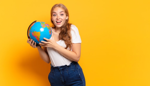 jovem loira segurando um mapa mundial