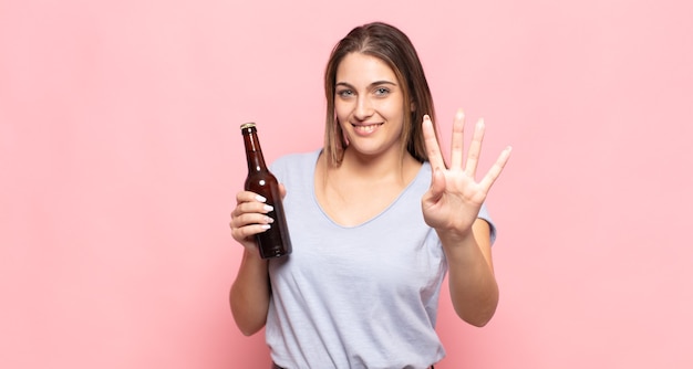 Jovem loira sorrindo e parecendo amigável, mostrando o número quatro ou o quarto com a mão para a frente, em contagem regressiva