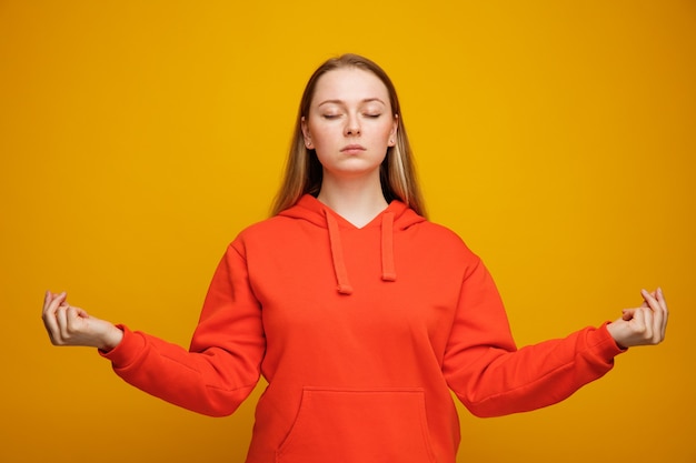 Jovem loira tranquila meditando com os olhos fechados