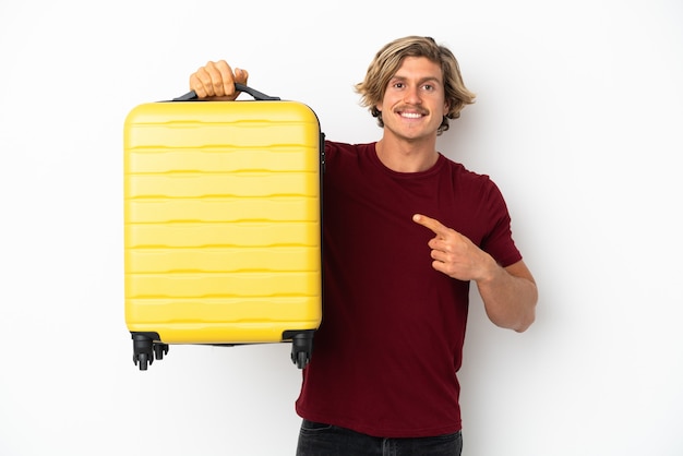 Foto jovem loiro isolado no fundo branco de férias com mala de viagem