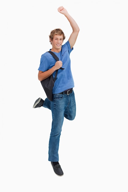Jovem loiro pulando com uma mochila