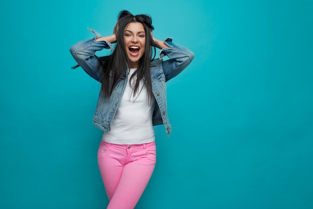 Jovem louca em jeans rosa e jaqueta jeans gritando