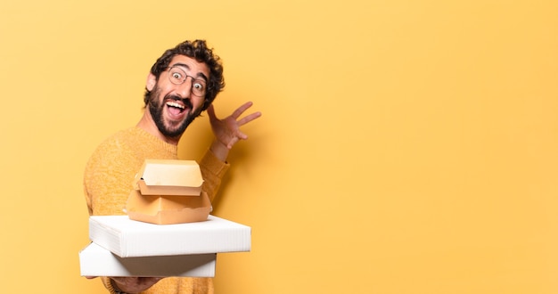 Jovem louco barbudo comendo fast food com um espaço de cópia