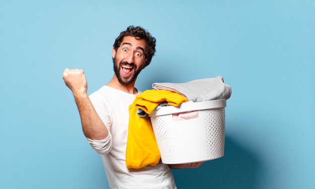 Jovem louco barbudo cuidando da casa lavando roupas