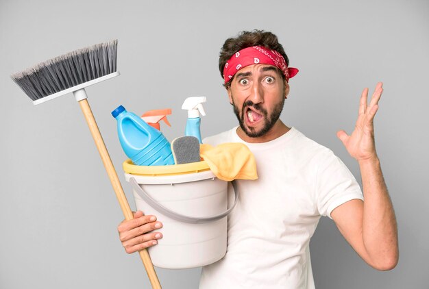 Jovem louco barbudo e expressivo com conceito de governanta de produtos limpos