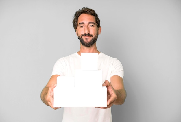 Foto jovem louco barbudo e expressivo segurando caixas de embalagem em branco