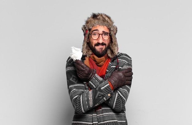 Jovem louco barbudo e vestindo roupas de inverno. conceito de doença