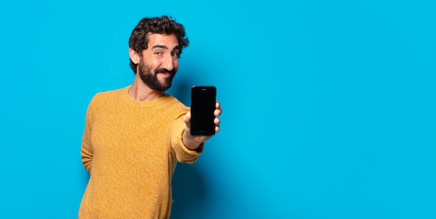 Jovem louco barbudo mostrando a tela do celular vazia