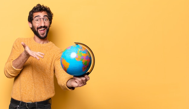 Jovem louco barbudo segurando um mapa do globo do mundo.