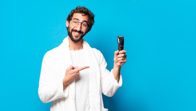 Jovem louco barbudo vestindo roupão de banho fazendo a barba concep