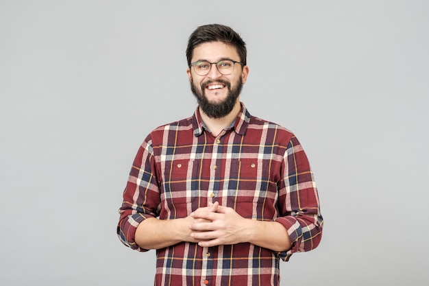 Jovem macho bonito com barba contra fundo cinza