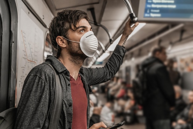 Jovem macho com máscara protetora no metrô Conscientização da saúde para proteção