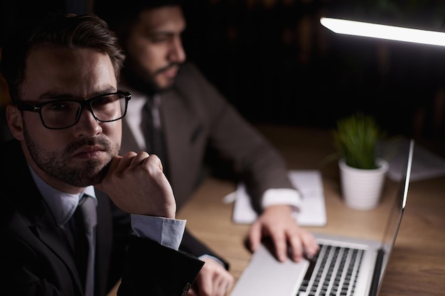 Jovem macho no escritório trabalhando no computador desktop