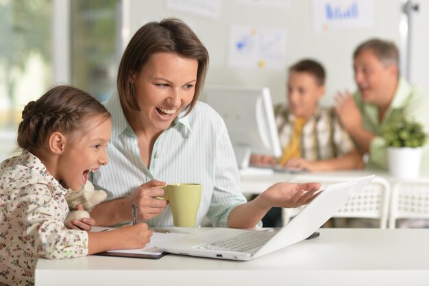 Jovem mãe ajudando sua filha bonitinha