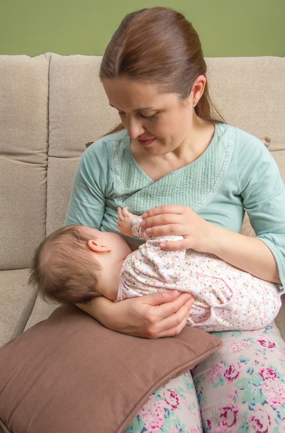 Jovem mãe amamentando seu bebê em casa