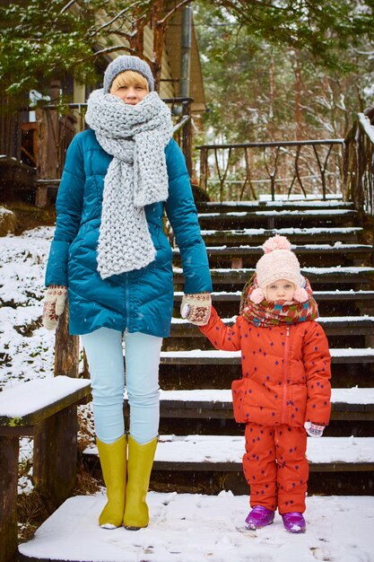 Jovem mãe brinca com seu bebê em um dia de inverno