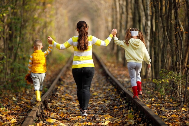 Foto jovem mãe carregando seu filho nas costas para viajar de trem mãe passando tempo com a família