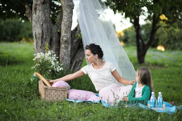 Jovem mãe com a filha em um piquenique no parque