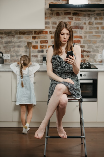 Jovem mãe com a filha na cozinha