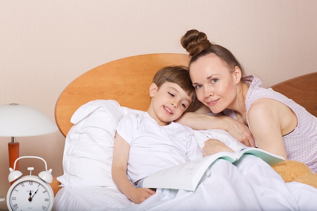 Jovem mãe com seu filho de sete anos na cama.