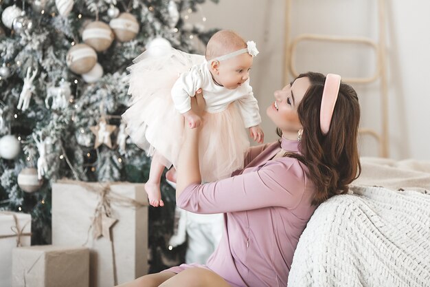 Jovem mãe com sua garotinha com decoração de natal