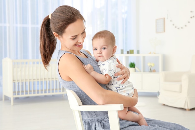 Jovem mãe com um bebê fofo em casa