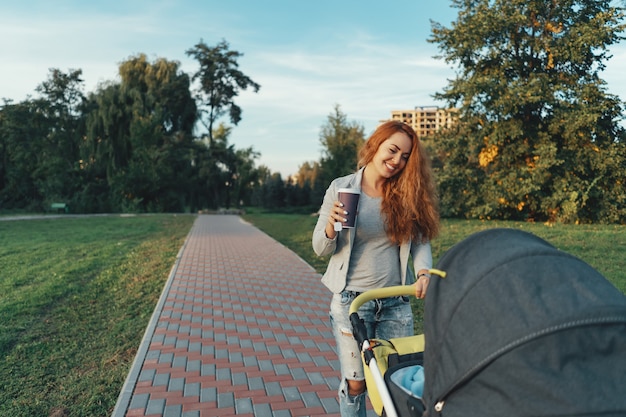 jovem mãe curtindo um passeio no parque com o bebê