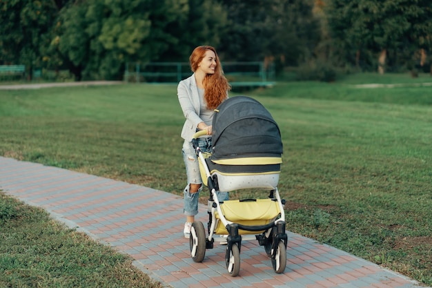 jovem mãe curtindo um passeio no parque com o bebê