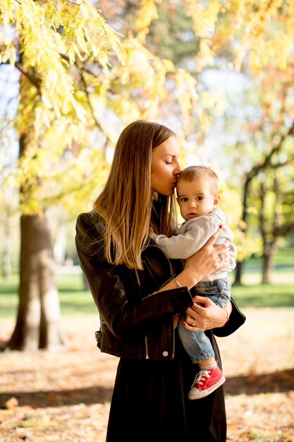 Jovem mãe e bebê menino no parque outono