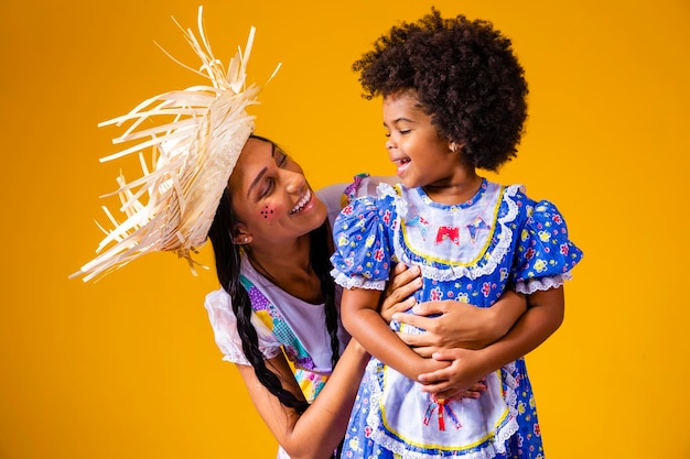 Jovem mãe e filha vestida com roupa de festa junina para a festa junina