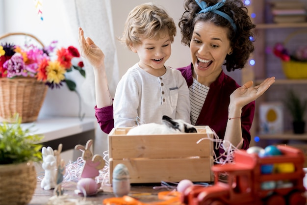 Jovem mãe e filho brincando com coelho de estimação