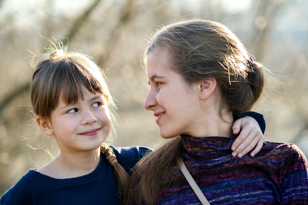 Jovem mãe e sua filha filha juntos ao ar livre.