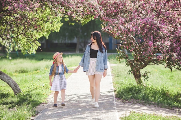 Jovem mãe e sua filha se divertindo ao ar livre