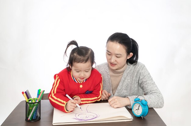 Jovem mãe ensina filha a pintar