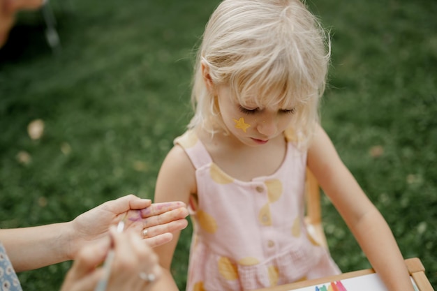 Jovem mãe está desenhando com seu filho no jardim. tempo para a família.