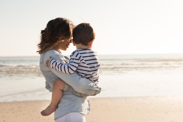 Jovem mãe explorando a praia com seu bebê