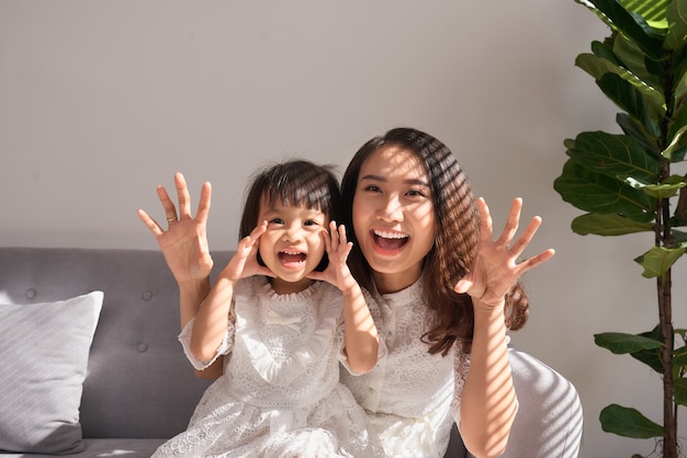 Jovem mãe feliz com a filha em casa