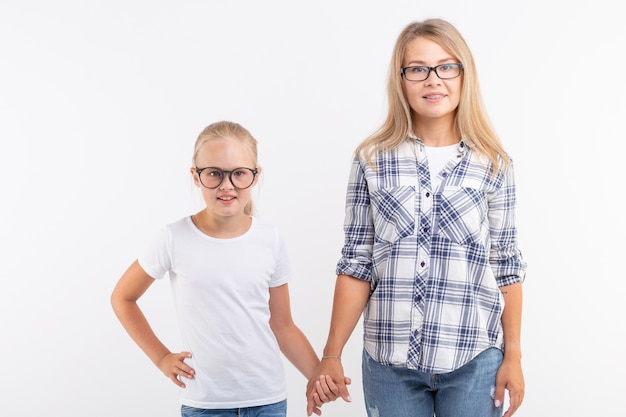 Jovem mãe feliz e criança rindo em óculos da moda se divertir no fundo branco