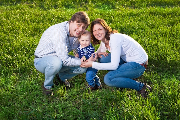 Jovem mãe feliz pai e filho se divertindo no campo