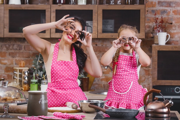 Foto jovem mãe linda e sua filha cozinhando na cozinha