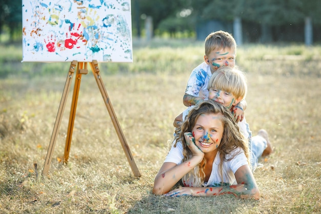 Jovem mãe pintando com seus filhos