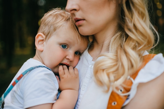 Jovem mãe segurando o filho na floresta