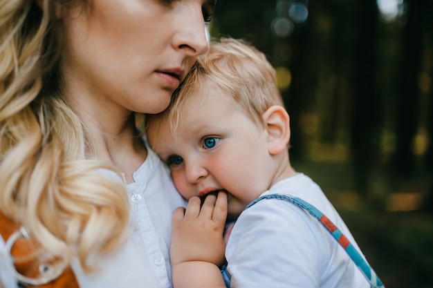 Jovem mãe segurando o filho na floresta